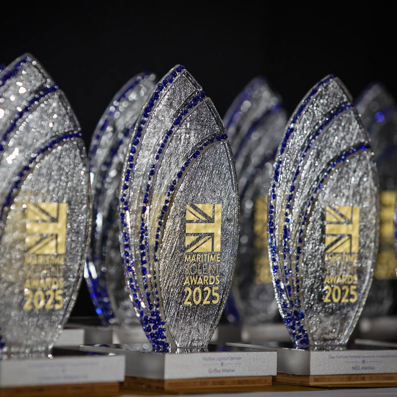Maritime PR and communications - Woman in high vis holding a microphone between her and the male interviewee. both with their heads turned towards the rail track in the background